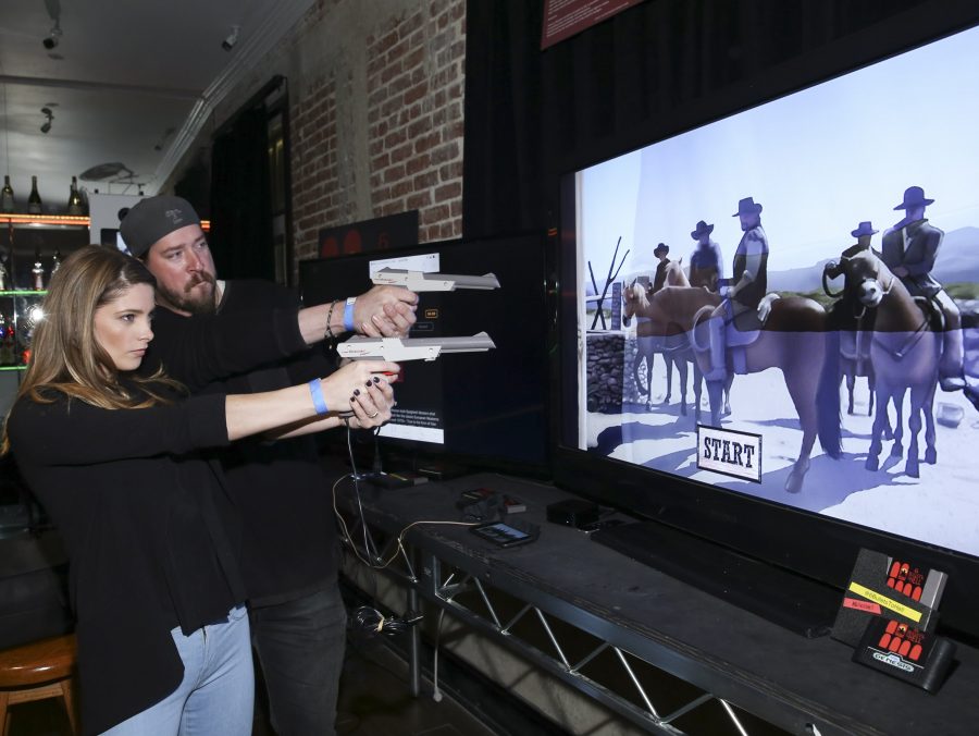 "LOS ANGELES, CA - MAY 10: Actors Ashley Greene (L) and Tanner Beard play 6 Bullets to Hell at the "6 Bullets To Hell" Mobile Game Launch Party on May 10, 2016 in Los Angeles, California. (Photo by Michael Bezjian/Getty Images for Silver Sail Entertainment)"