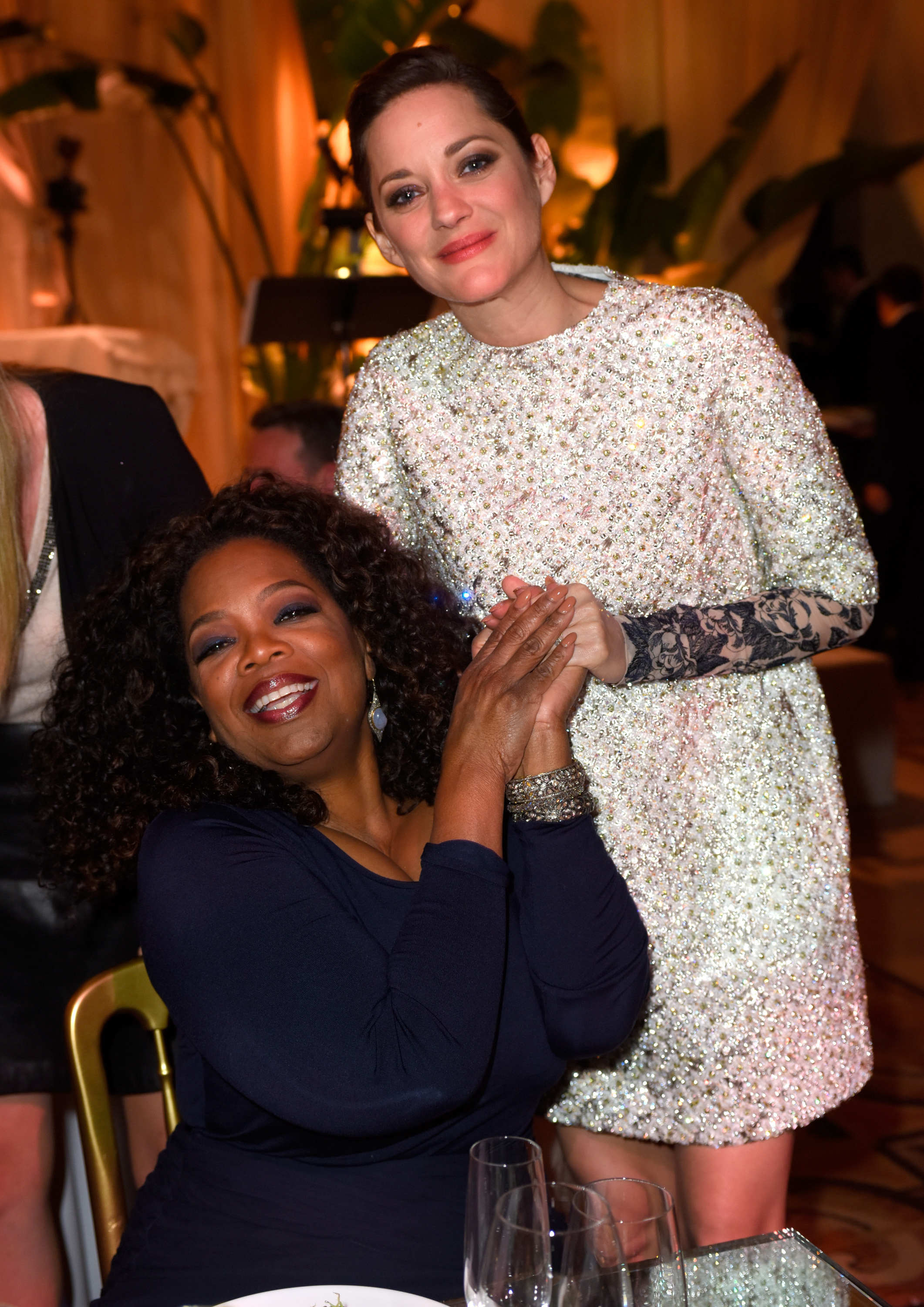 Producer/actress Oprah Winfrey (L) and actress Marion Cotillard attend The Weinstein Company's Academy Awards Nominees Dinner