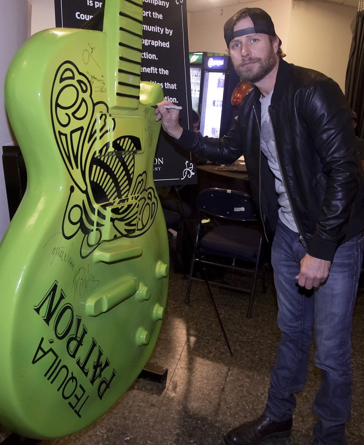 Dierks Bentley signs a giant Patrón tequila guitar backstage at the CMA Awards Monday November 2, 2015.