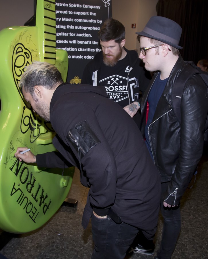 Fall Out Boy signs a giant Patrón tequila guitar backstage at the CMA Awards Tuesday November 3, 2015.