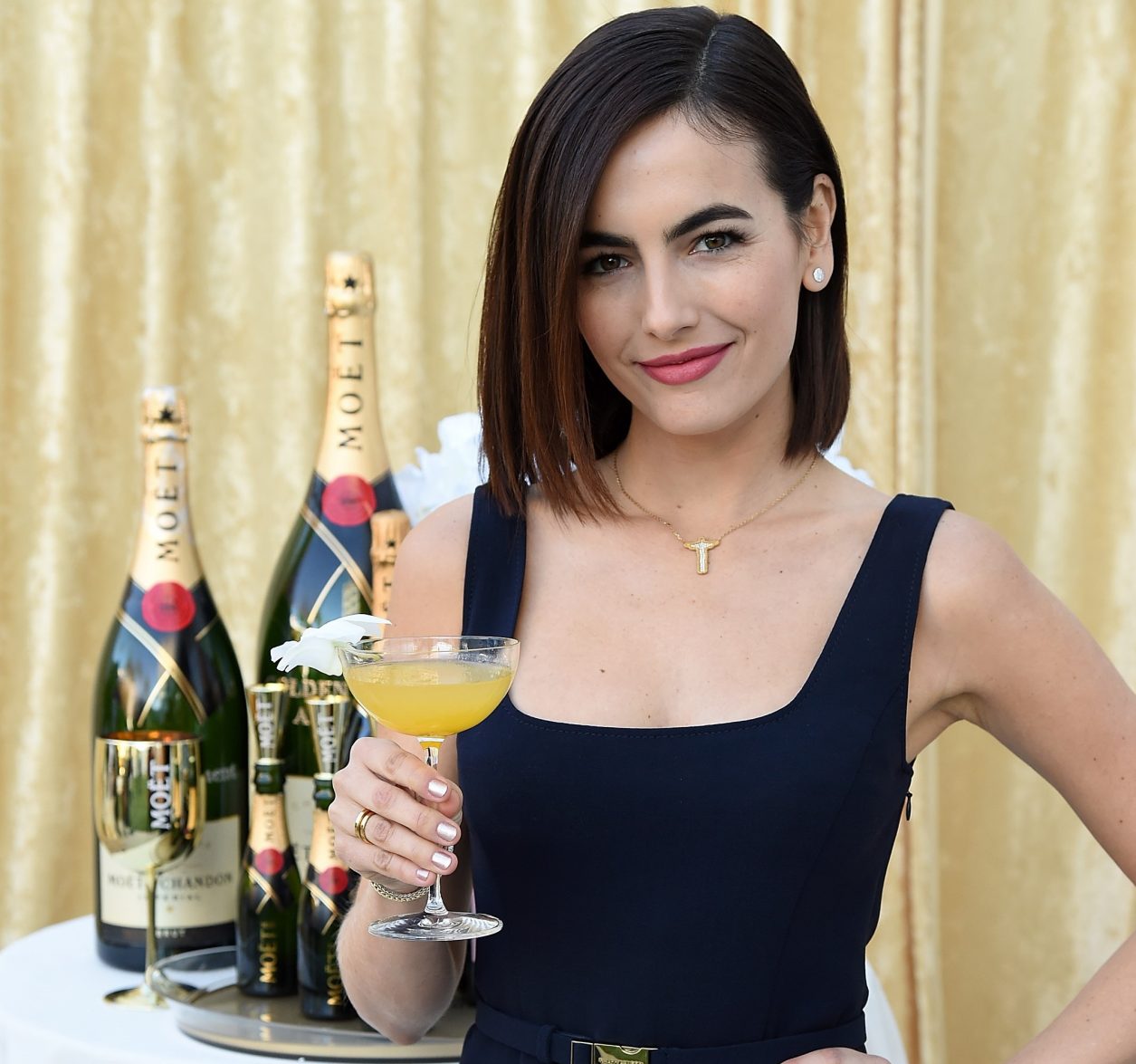 BEVERLY HILLS, CA - DECEMBER 13:  Camilla Belle poses with the signature cocktail for the 2019 Golden Globes, The Moet Belle, on display at the 76th Golden Globe Awards Show Menu Unveiling at The Beverly Hilton Hotel on December 13, 2018 in Los Angeles, California.  (Photo by Michael Kovac/Getty Images for Moet & Chandon)